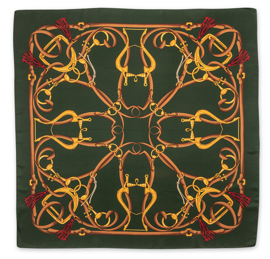 A square silk scarf featuring an intricate equestrian design with golden and brown horse bits and reins on a dark forest green background, finished with red tassels in the corners.