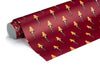 A roll of wrapping paper featuring a repeating pattern of classic Christmas leg lamps on a deep red background, with the roll positioned diagonally across the frame.